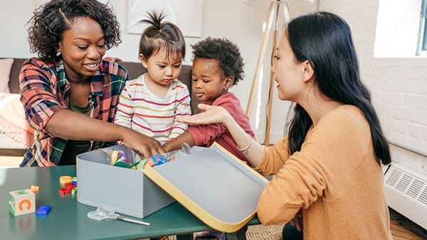 Two women interacting with two children